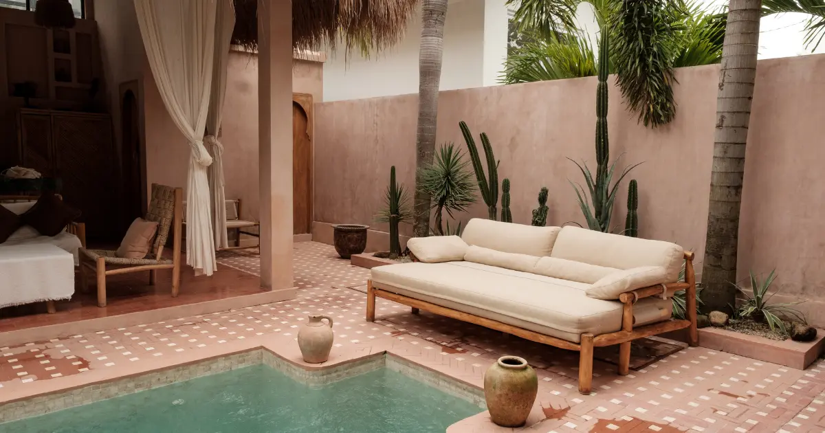 Beautiful Bali villa courtyard featuring a pool, terracotta tiles, natural elements, and organic fabrics, showcasing the top design trends of 2025.