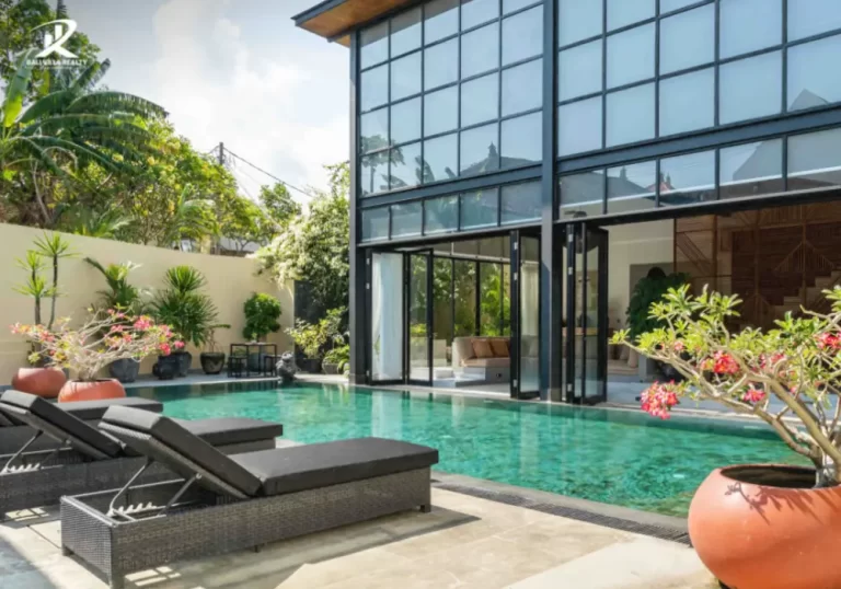 Modern 5-bedroom villa in Pererenan with sleek design, poolside lounge area, black-framed glass doors, and tropical landscaping