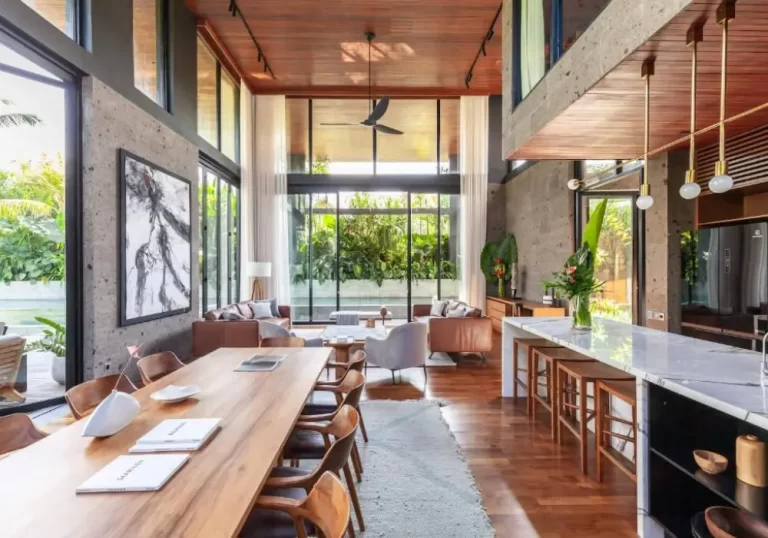 Open-plan dining and kitchen space at The River House in Pererenan, featuring natural wood, granite finishes, and mid-century accents.