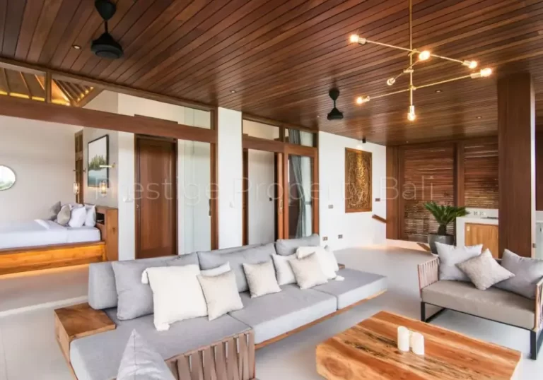 Modern tropical villa living room in Bali featuring wood ceilings, stylish furnishings, and indoor-outdoor flow.