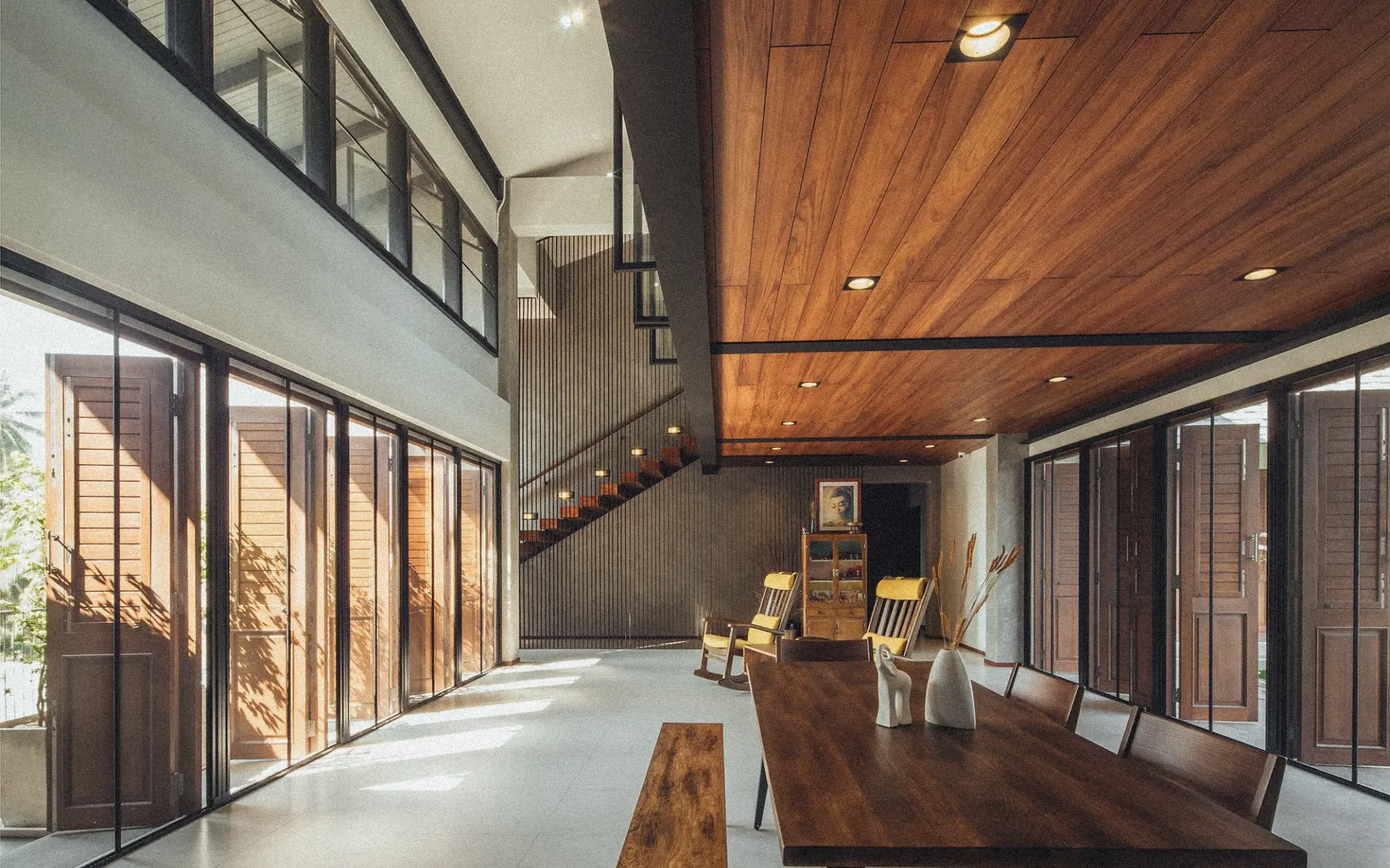 Stylish modern Bali villa interior dining room with teak wood ceiling floating staircase recessed lighting