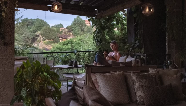 Customer sitting by the window at Zest Ubud with jungle views and two mugs of cacao.