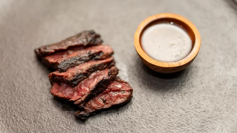 Closeup of medium-rare wood-fired steak with aioli sauce, beautifully plated at Fuego, Pererenan, Bali