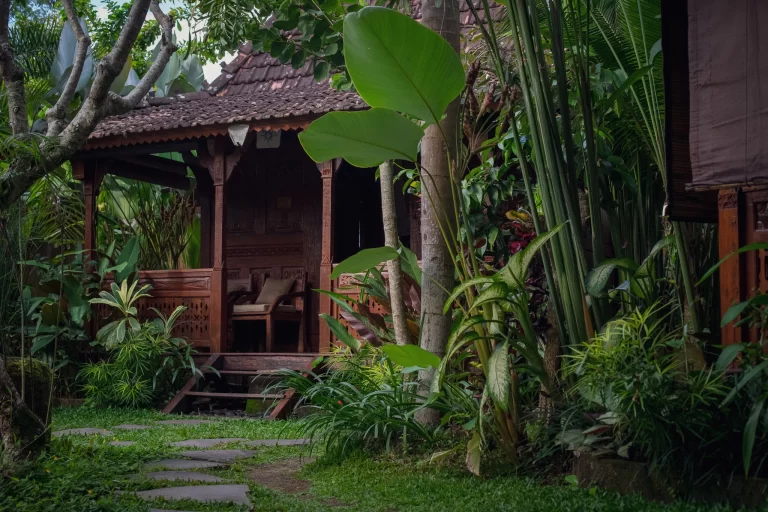 Wooden villa patio at Madani Antique Villas surrounded by lush jungle plants in Ubud, Bali