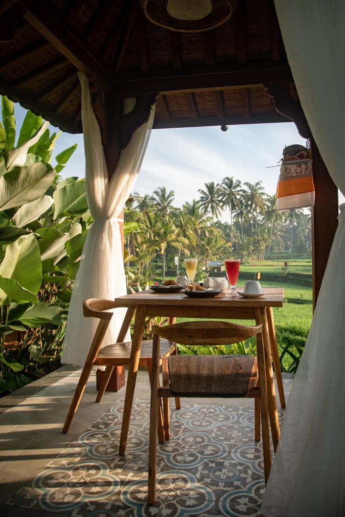 Breakfast table on private villa patio at Madani Antique Villas, overlooking rice fields, Ubud, Bali