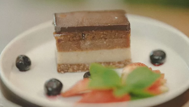 Plant-based raw chocolate cake at The Cashew Tree, Bingin — layered, creamy, and garnished with mint and fresh fruit, perfect for a post-workout or wellness treat.