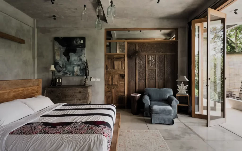 Concrete bedroom at RiverView Gardens with carved wall and jungle view doors