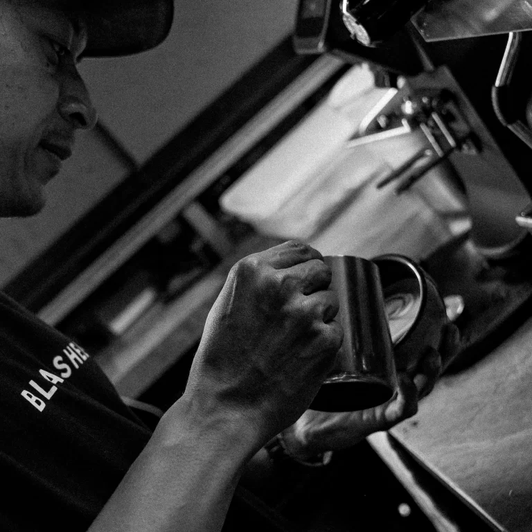 Barista preparing coffee behind the counter at Black Sheep Ubud