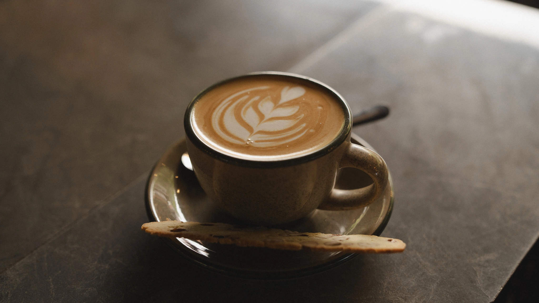 Cappuccino with biscotti and latte art at Black Sheep Ubud