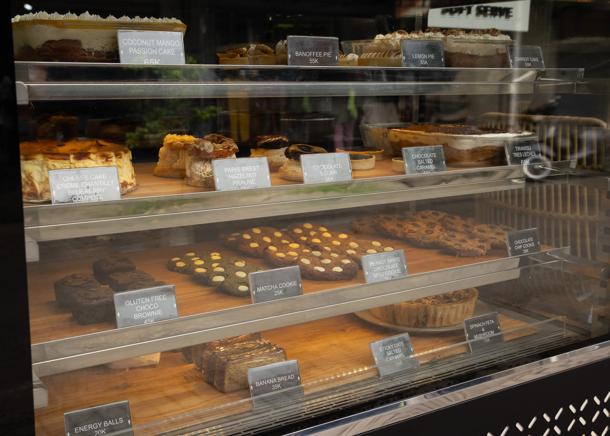 Glass dessert case filled with cakes, pies and cookies at Black Sheep Ubud