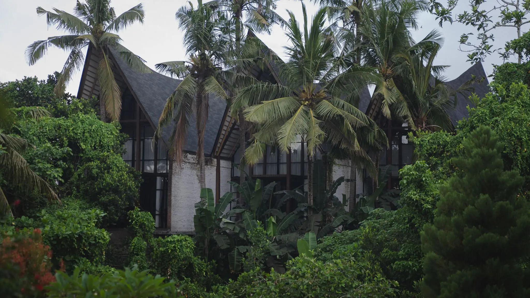 Sanctuary Villas Ubud — row of modern jungle-framed villas with timber and metal accents against lush greenery