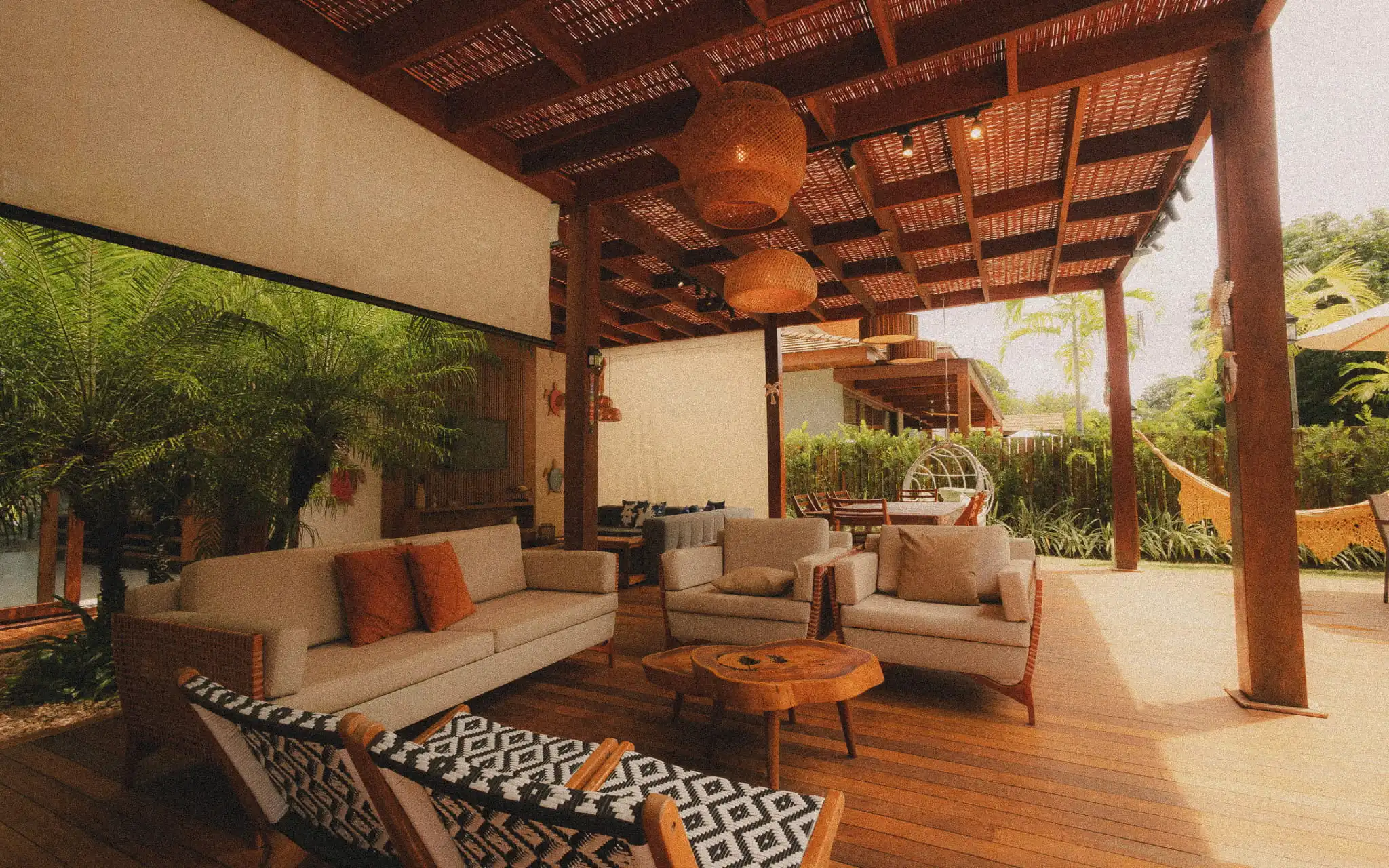 Open-air Bali villa living room and dining space with rattan furniture, woven chairs, and a staged interior featuring a neutral stock-style aesthetic.
